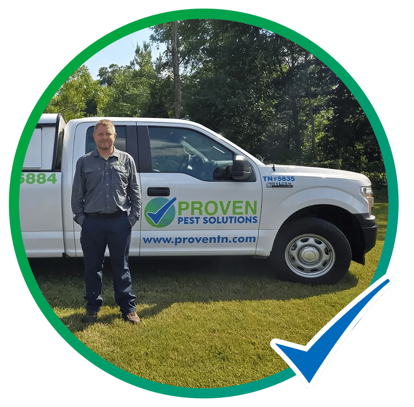 Proven Pest Solutions technician standing beside a company truck